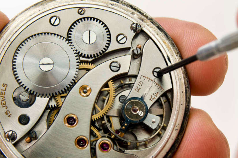 Relojero usando destornillador de precisión en un reloj de bolsillo