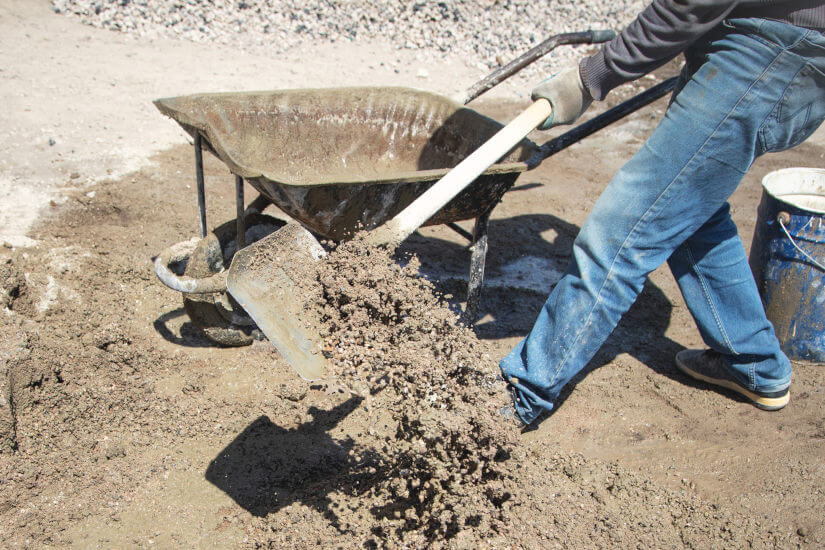 Trabajador usa pala cuadrada para hacer hormigón en el suelo