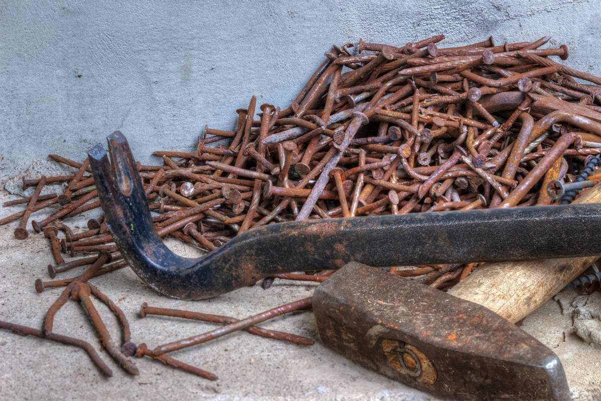 Clavos oxidados junto a martillo y palanca tipo pata de cabra