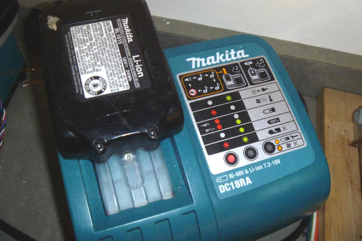 Batería Makita de 18 V en proceso de carga con led indicativo en rojo (carga inferior al 80%).