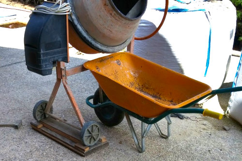 Forma de calzar las patas de una hormigonera para volcar el cemento en una carretilla profunda.