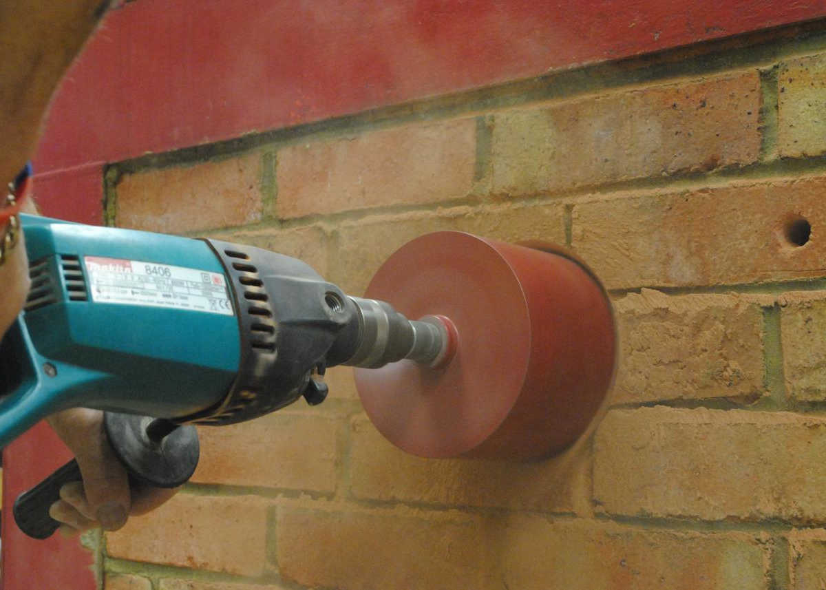 Corte de una pared de ladrillo con sierra de corona