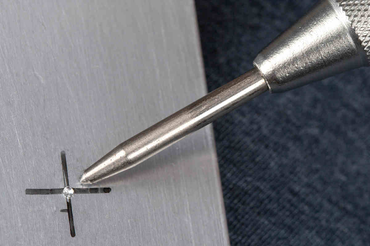 Marca dejada por un graneteador automático sobre una chapa metálica.