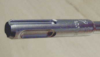 Detalle del sistema sds-plus: componente macho (broca) con ranuras abiertas y cerradas y extremo achaflanado. 