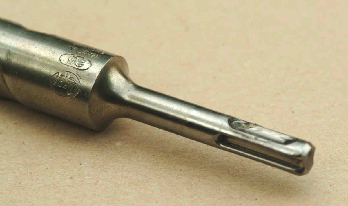 Vastago SDS-Plus de una broca para martillo perforador: detalle de una ranura abierta contra otra cerrada