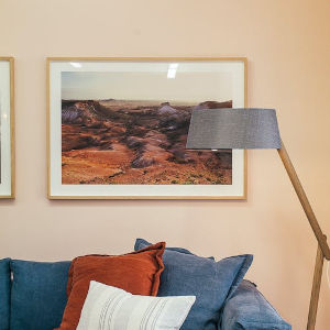 cuadro colgado sobre el sofá en la pared del salón de una vivienda junto a una lámpara