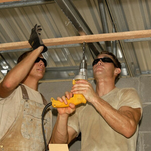trabajadores usando un taladro percutor con cable