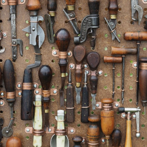 panel de instrumentos en un banco de trabajo del que cuelgan herramientas antiguas