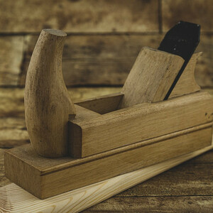 cepillo de carpintería tradicional construido en madera con cuña y hoja de acero